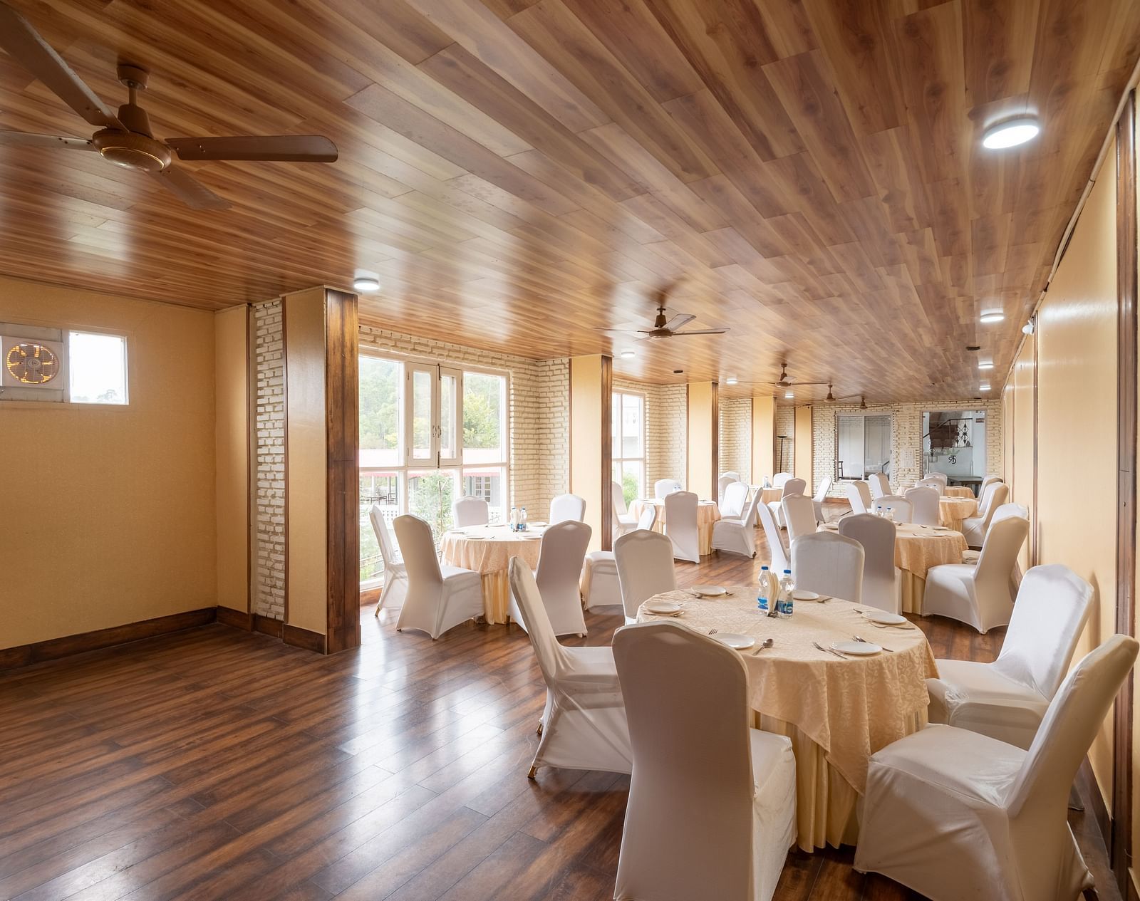Well-lit banquet hall at DLS Tehri Club Resort with tables and chairs set for a meeting or event